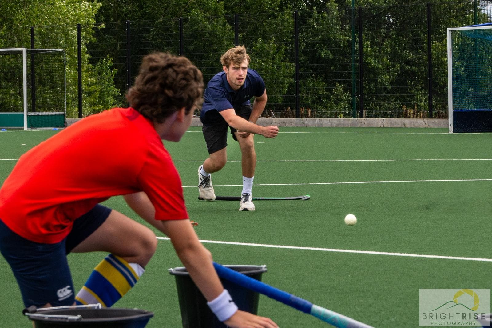 A coach passing to a young player during a hockey session